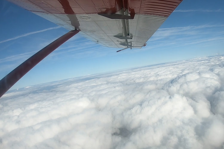 View above the clouds during a skydive, seen from the plane