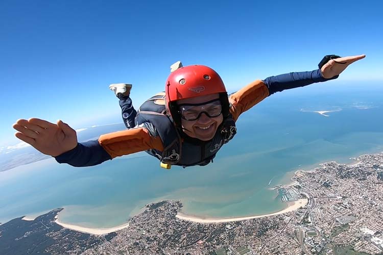 Skydiver in vrije val boven Royan aan de Franse Atlantische kust, met stad en stranden onder zich.