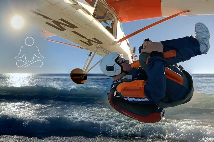 Ground Control skydiving in Royan: skydiver in a backflip after exit above the Atlantic coast, with sun and sea.