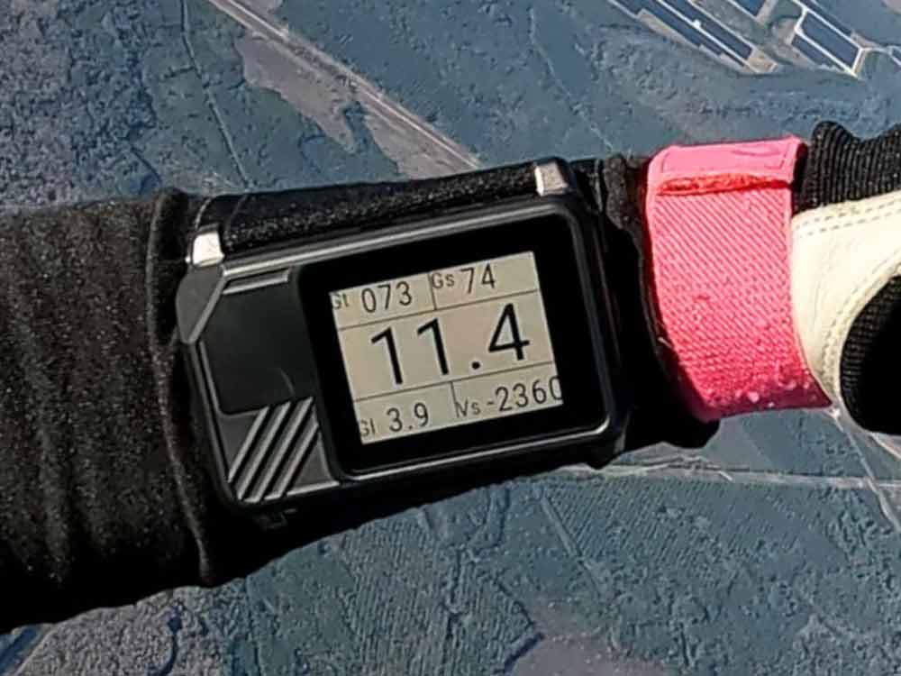 Digital altimeter on the wrist in freefall Digital skydiving altimeter on the wrist in freefall, altitude awareness above the landscape.