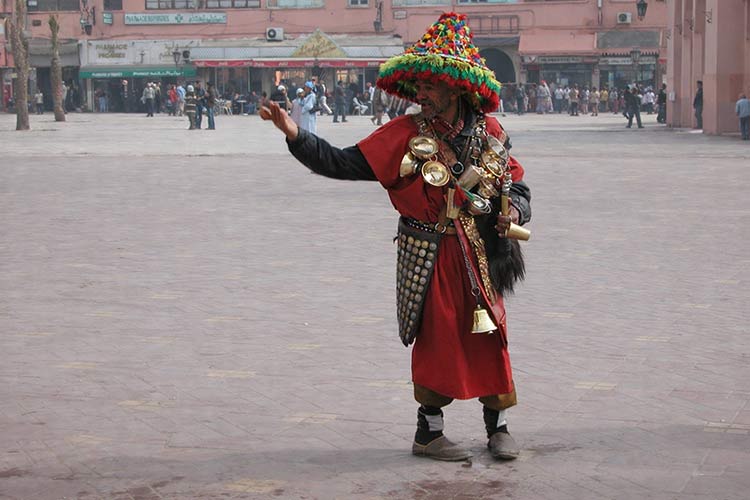 Straatbeeld tijdens een uitstapje naar Marrakech Waterverkoper in traditionele kleding op een plein in Marrakech