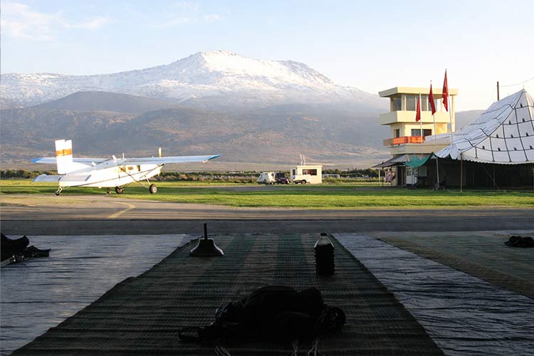 Uitzicht op het Atlasgebergte vanuit de hangaar Vliegtuig en hangaar met uitzicht op het Atlasgebergte in Beni Mellal