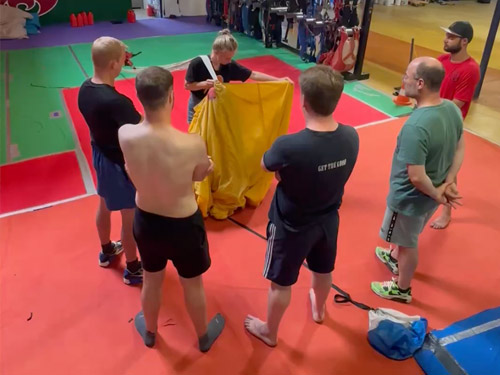 Skydiveweek Royan – uitleg parachute vouwen Instructeur demonstreert hoe je een parachute vouwt aan deelnemers van de skydiveweek in Royan.