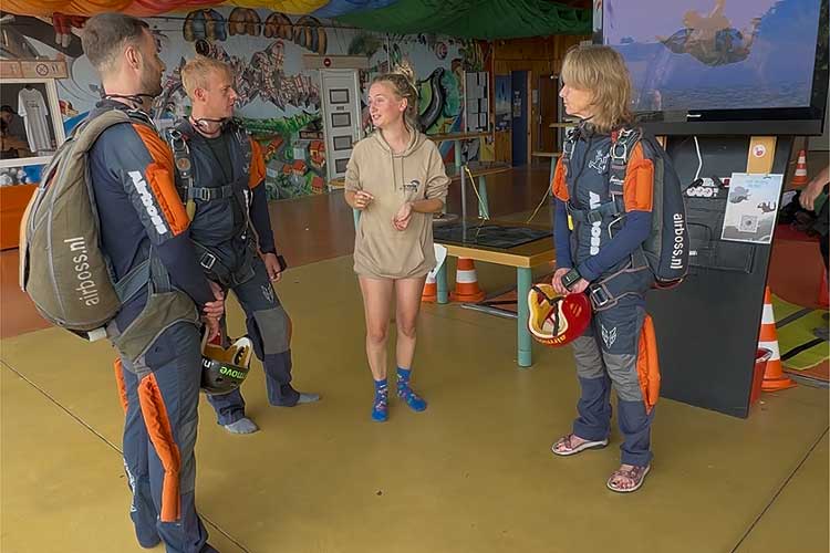Drie Airboss-cursisten krijgen uitleg tijdens de opleiding voor hun eerste sprong.